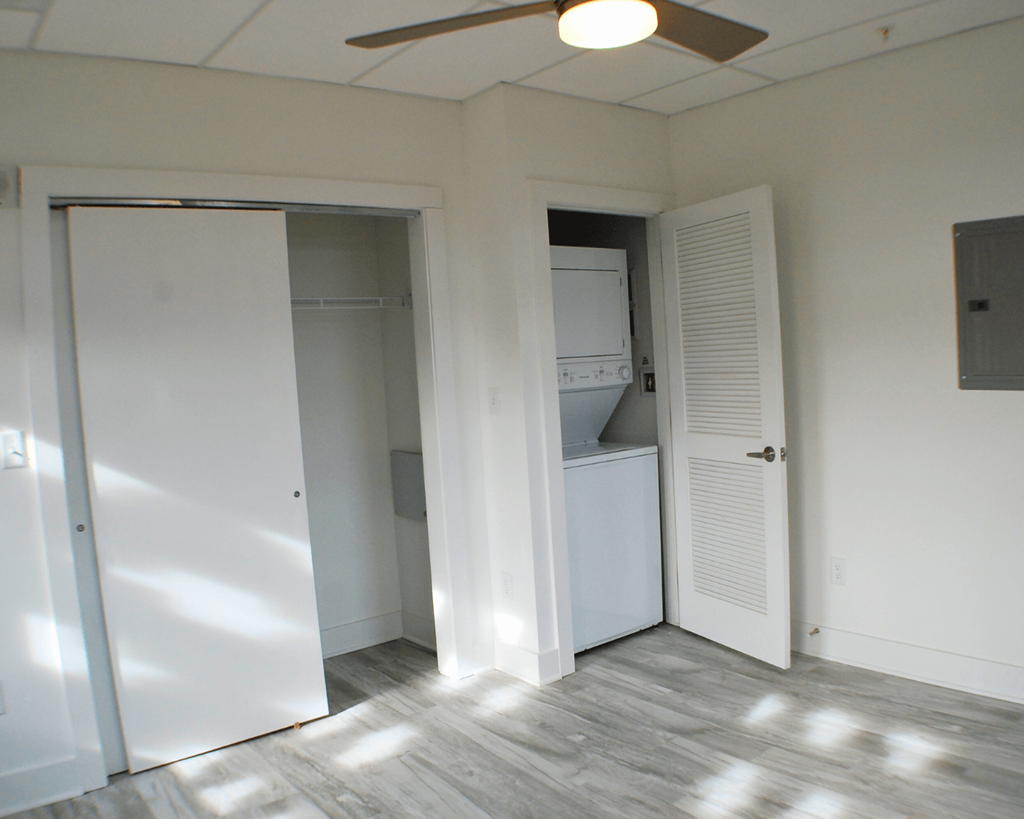 A room with a white door and a white refrigerator.