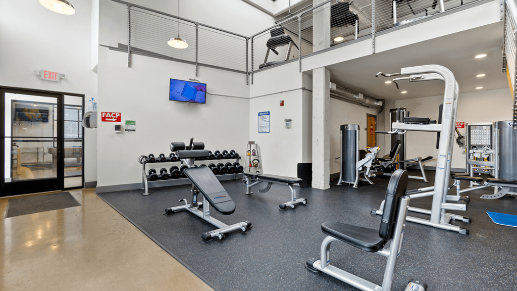 a gym with weights and other equipment in a building with a glass door