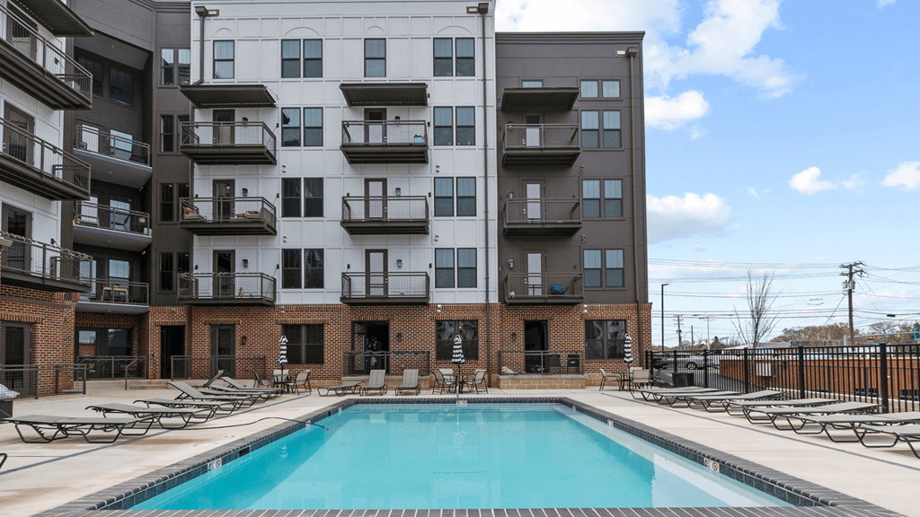 a swimming pool in front of an apartment building