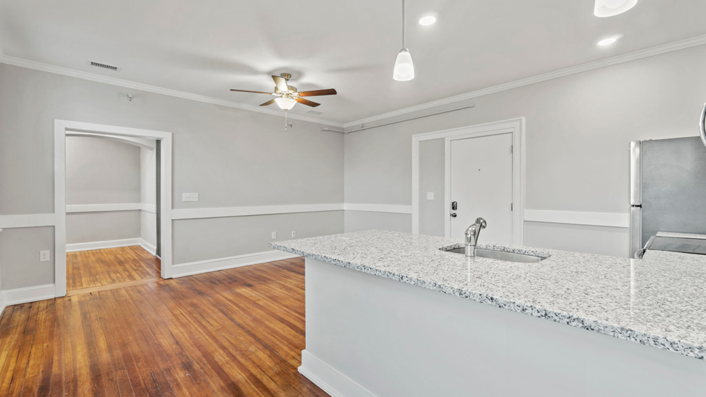 an empty kitchen with a counter top and a ceiling fan