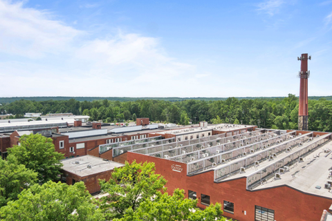 an aerial view of a building with many solar panels on the roof