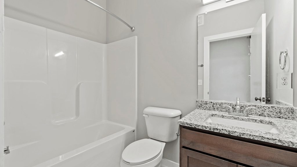 a bathroom with a toilet sink and shower and a mirror