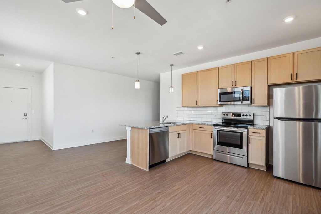 a large kitchen with wooden flooring and stainless steel appliances