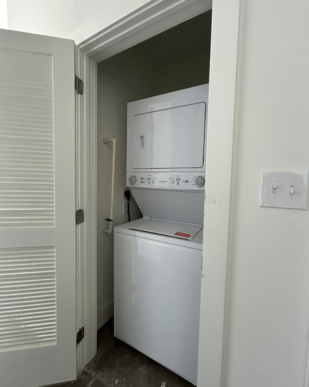 an empty laundry room with a washer and dryer in it