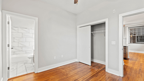 a bedroom with a door to a bathroom and a closet