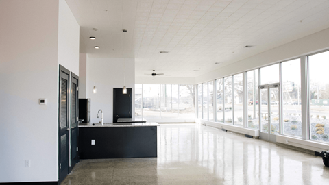 a large room with large windows and a counter in the middle of it