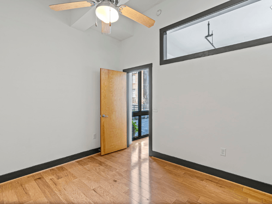 a living room with a large window and a door to a balcony