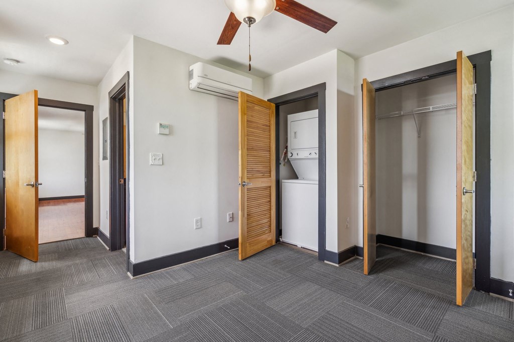 an empty room with two doors and a laundry room