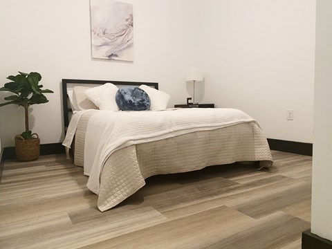 a bedroom with a bed and a wooden floor