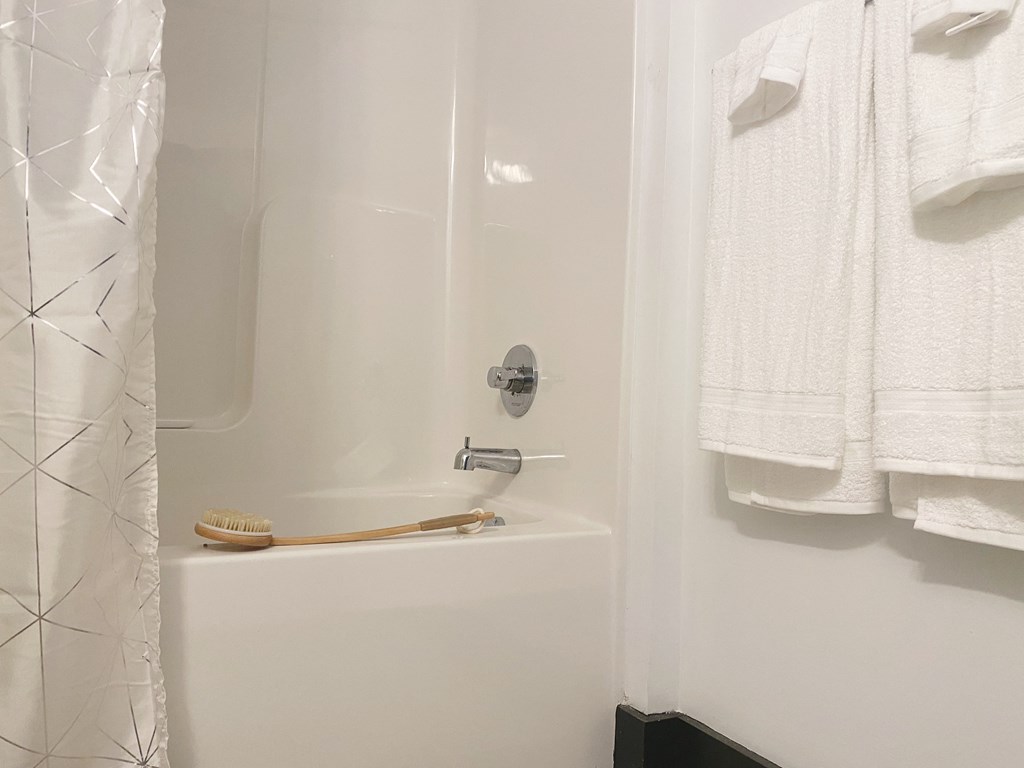 a small bathroom with a shower and white towels