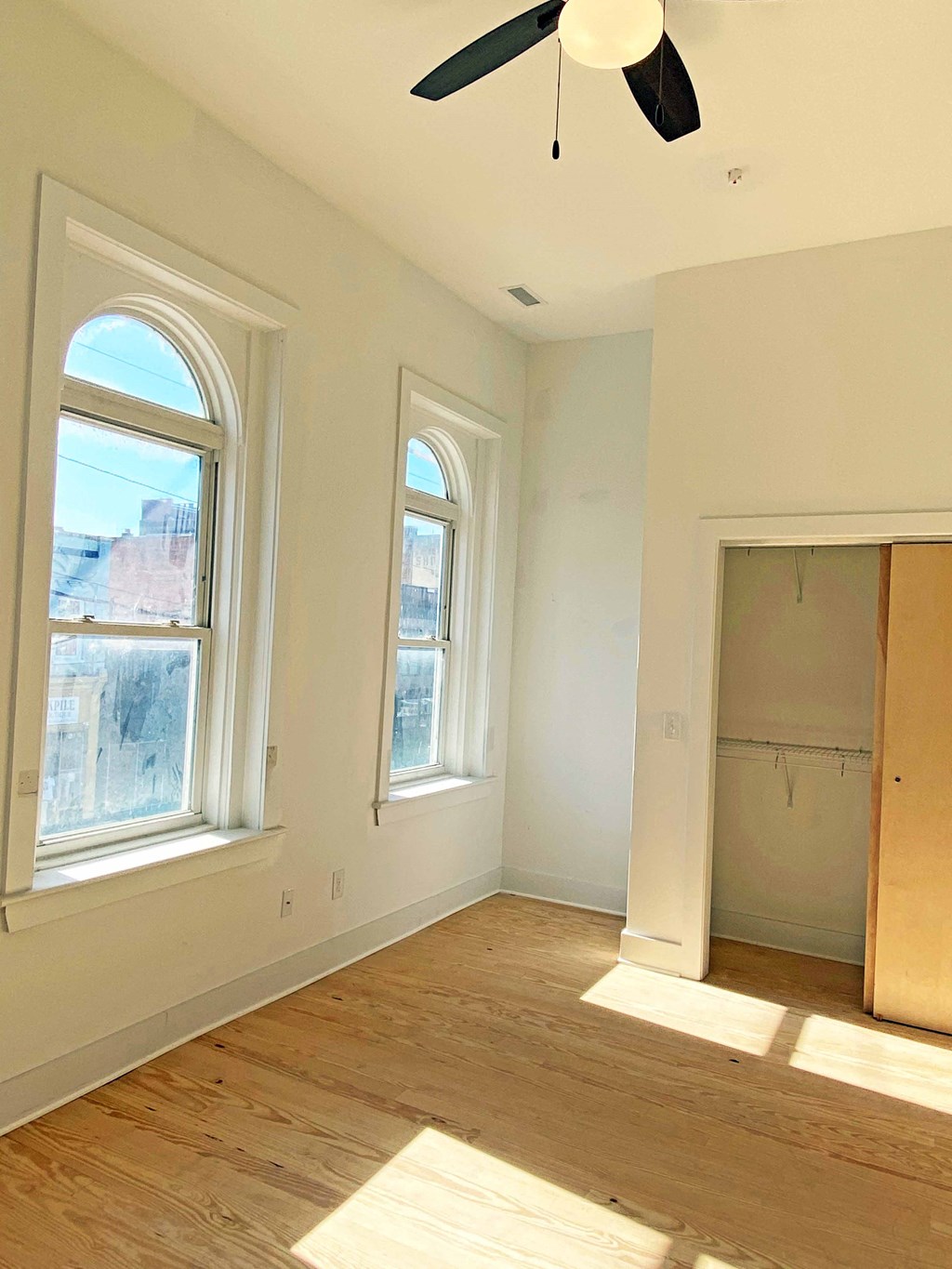 an empty room with two windows and a closet