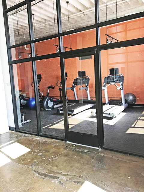 A gym with orange walls and a glass wall.