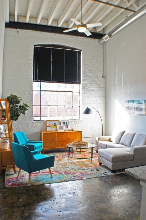 A living room with a blue chair and a white couch.