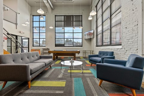 A modern living room with a grey sofa, blue armchair, and a coffee table.
