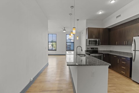 A kitchen with a granite countertop and stainless steel appliances.