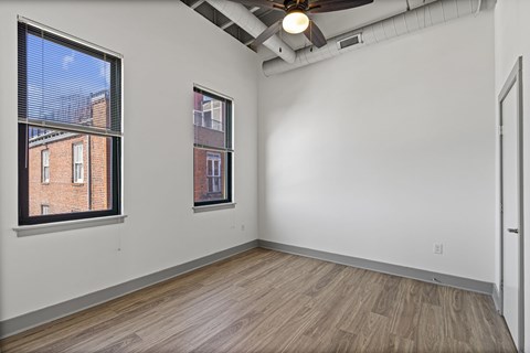 A room with a window and a ceiling fan.