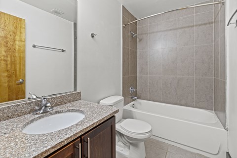 A bathroom with a white tub, sink, and toilet.