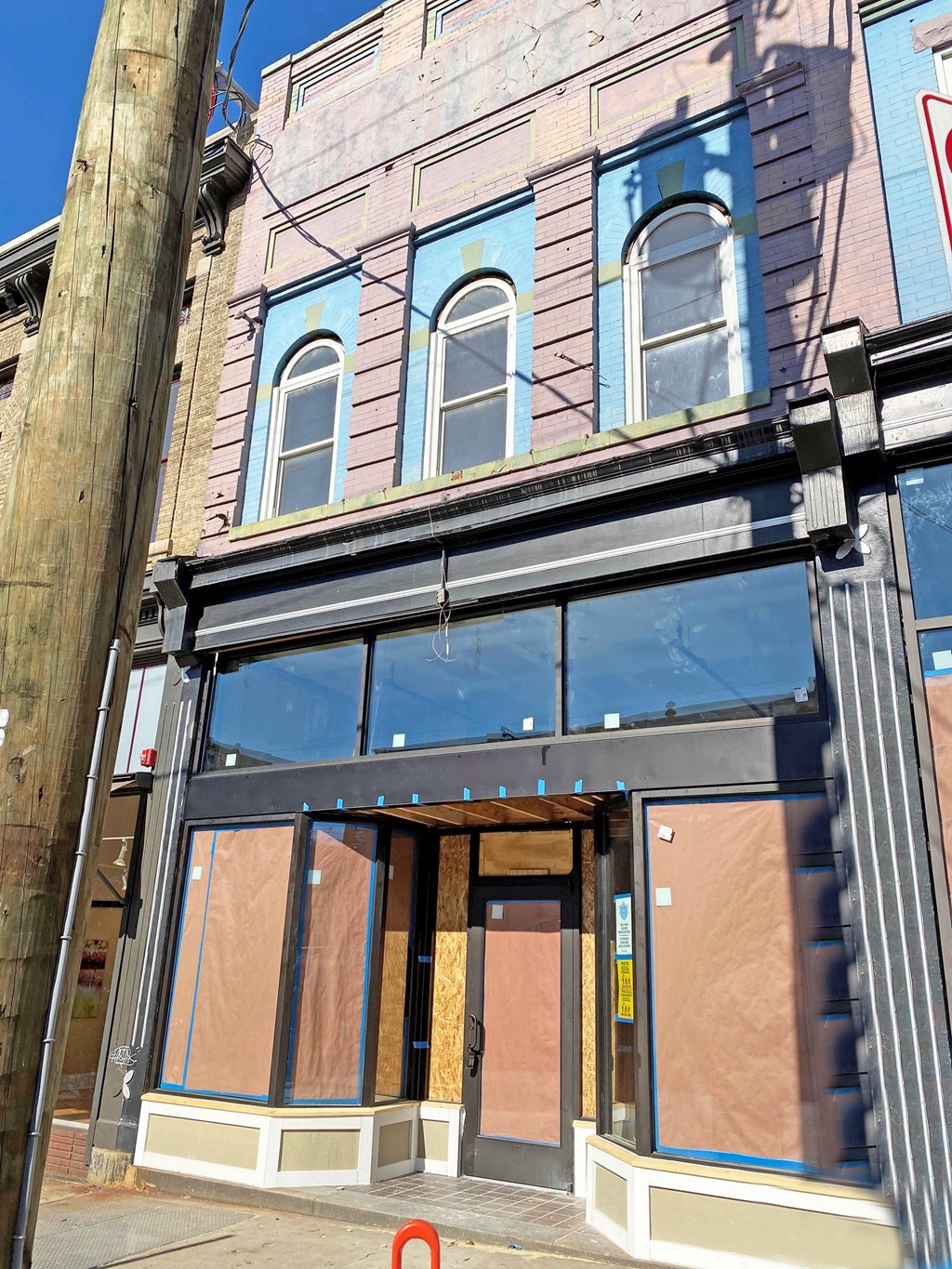 the front of a building with boarded up windows