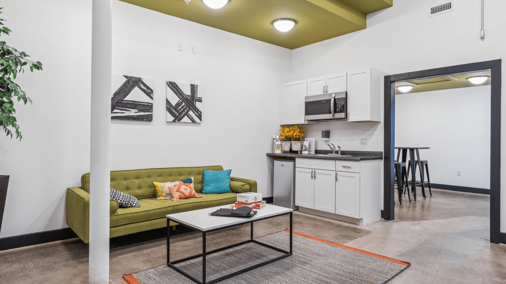 A living room with a green couch and a coffee table.