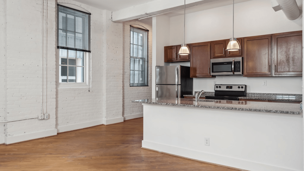 A kitchen with wooden cabinets and a stainless steel refrigerator.