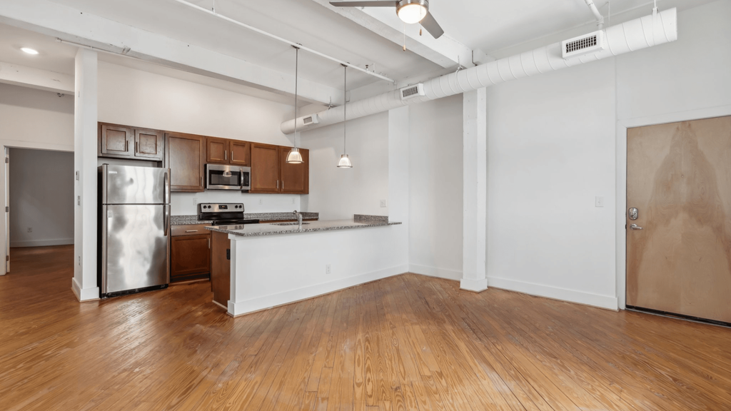 A kitchen with a refrigerator, microwave, and oven.