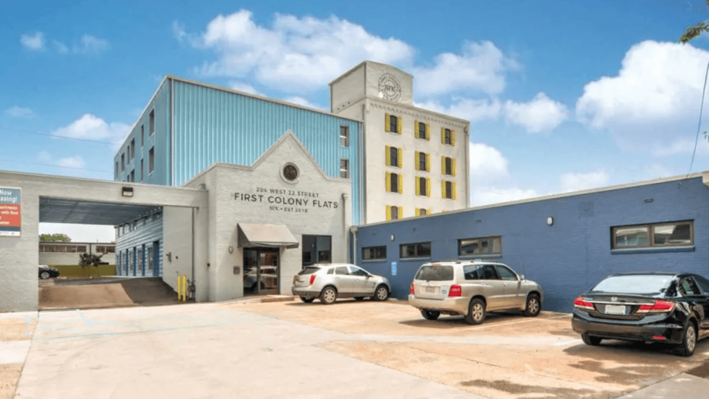 A car dealership with a sign that says "FIRST ON THE MARKET" on the side of the building.
