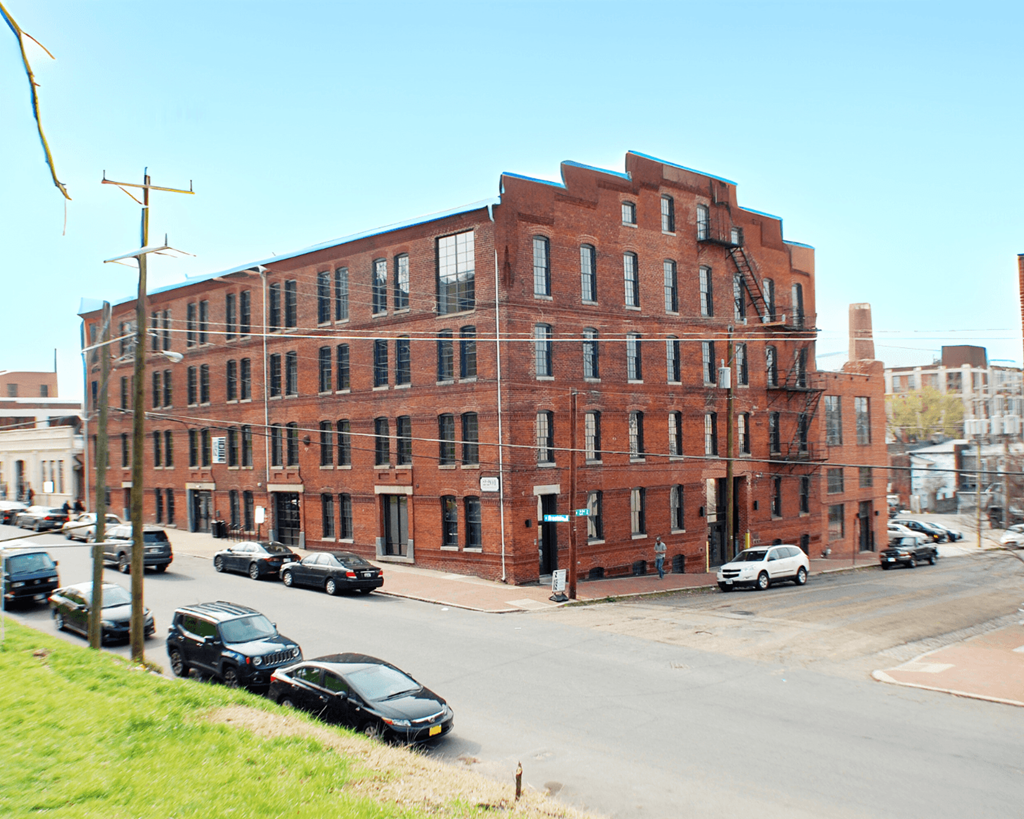 A red brick building with a black car in front of it.