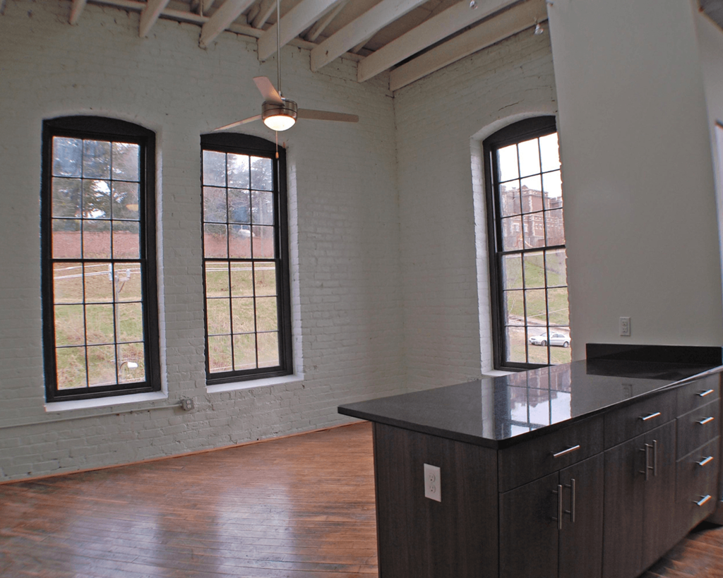 A room with a large island and three windows.