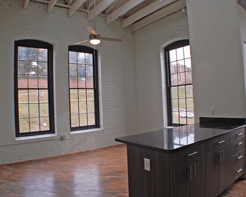A room with a large island and three windows.