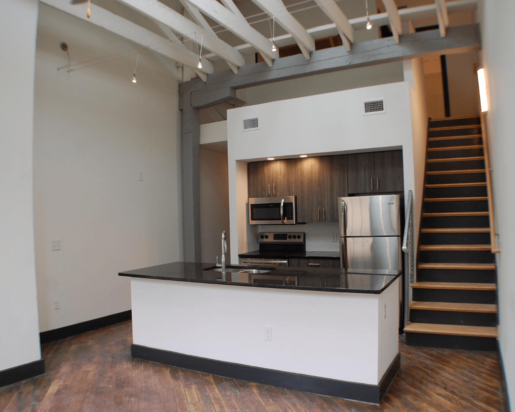 A kitchen with a stainless steel refrigerator and stove.