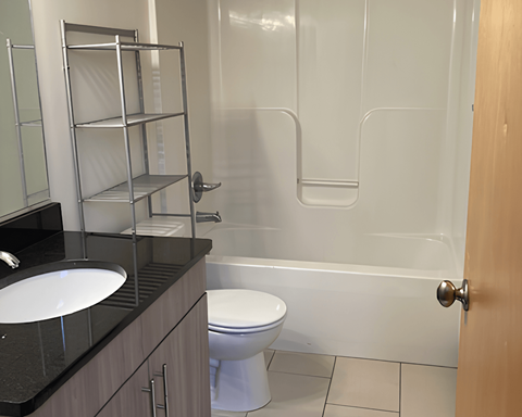 A white toilet sits in a bathroom next to a sink.