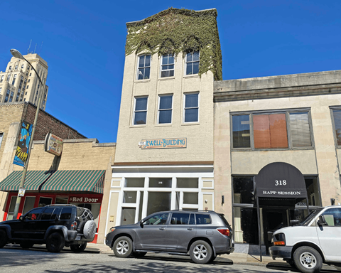 A building with a green awning and a sign that says "Wellness" is in the background.