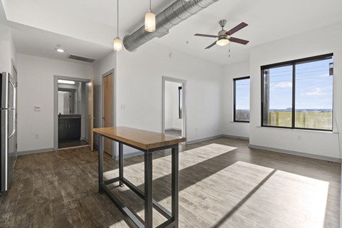 A spacious room with a table and a ceiling fan.