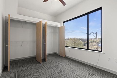 A room with a ceiling fan and a window overlooking a landscape.