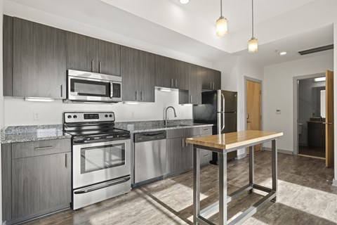 A modern kitchen with stainless steel appliances and wooden accents.