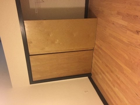 A wooden drawer is in a cabinet.