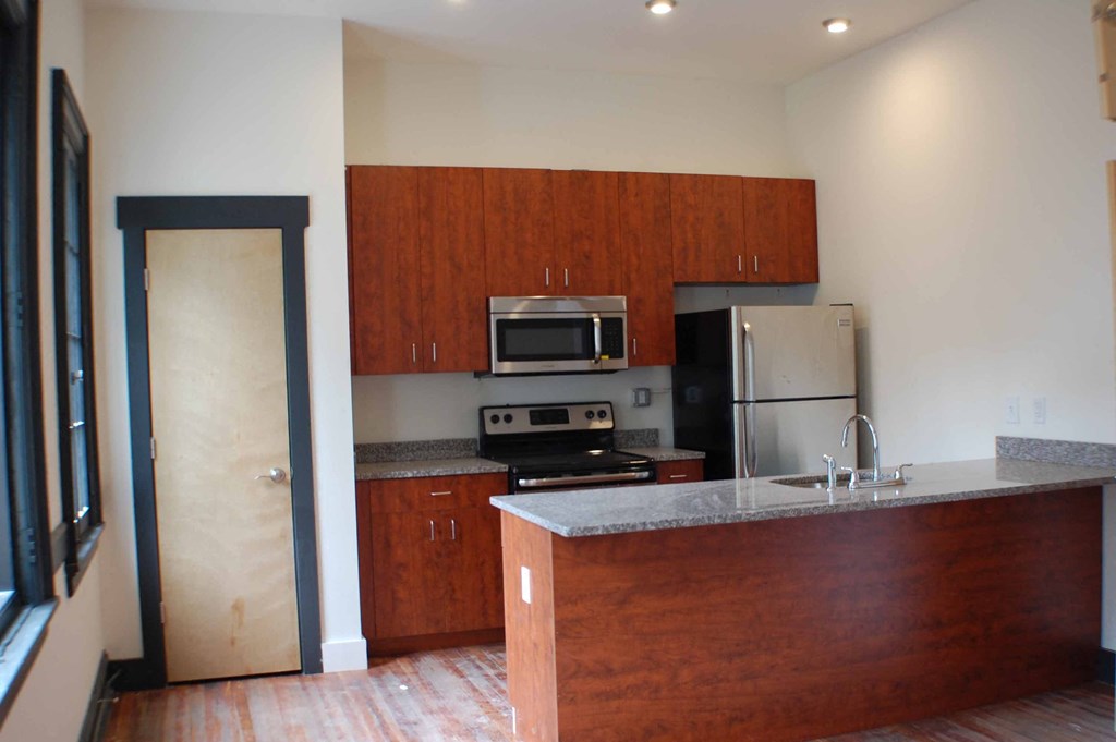 A kitchen with wooden cabinets and a counter.