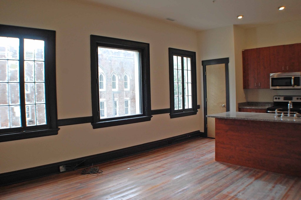 A kitchen with a wooden floor and a window.
