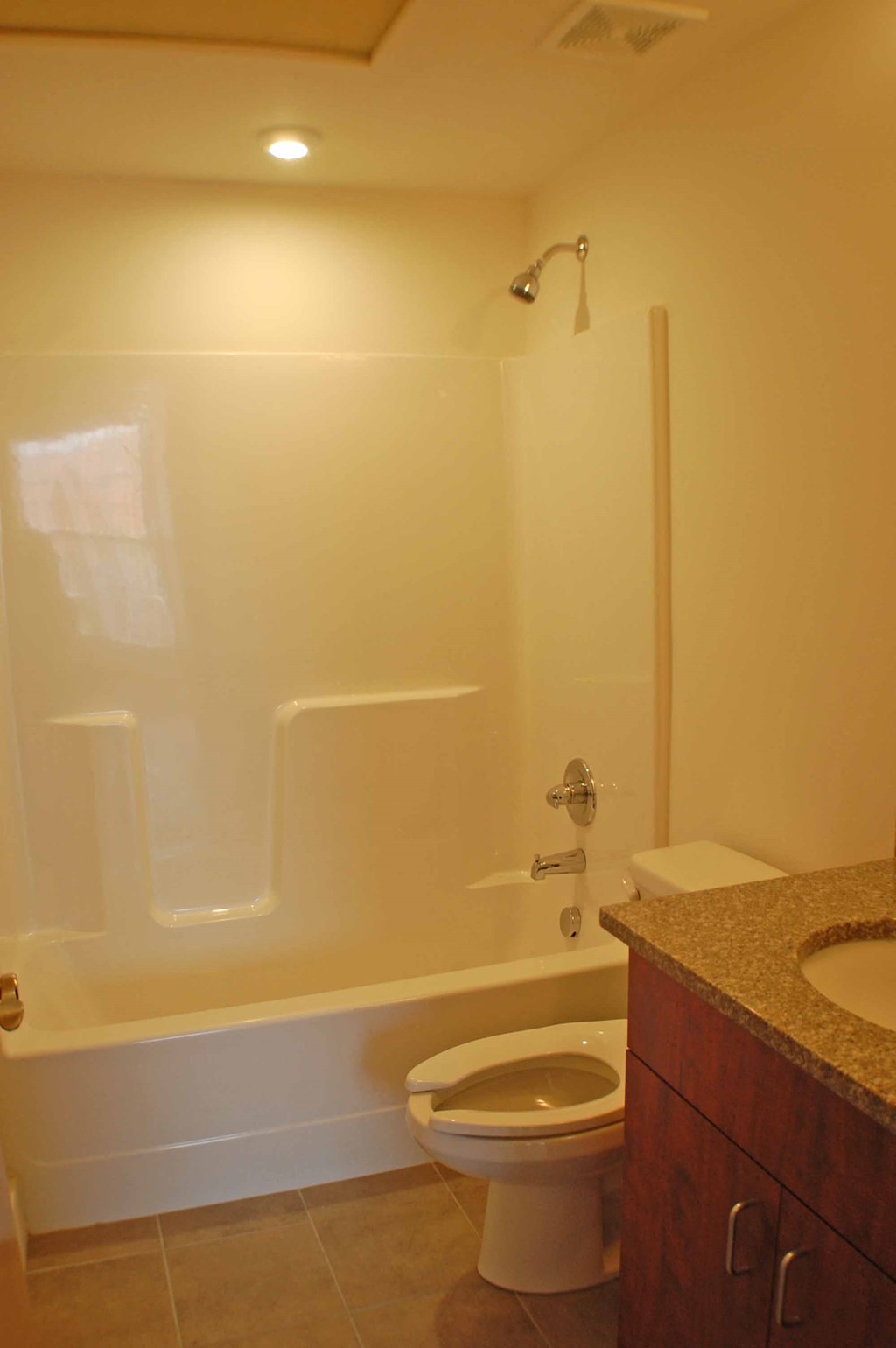 A white toilet is in a bathroom with a walk-in shower.