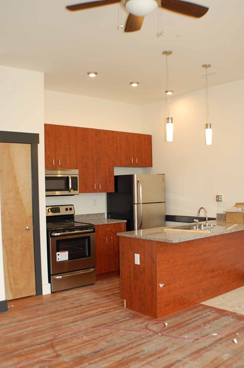 A kitchen with wooden cabinets and a refrigerator.