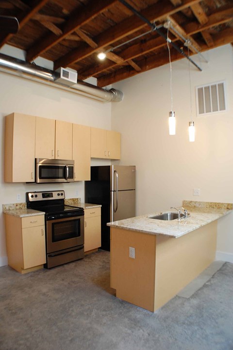 A kitchen with wooden cabinets and a stove top oven.