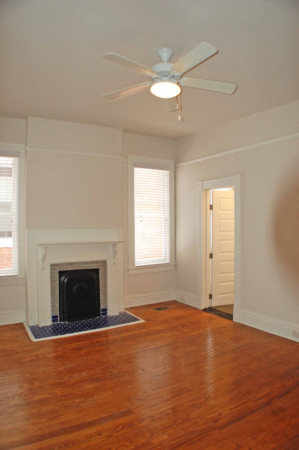 A room with a fireplace and a ceiling fan.