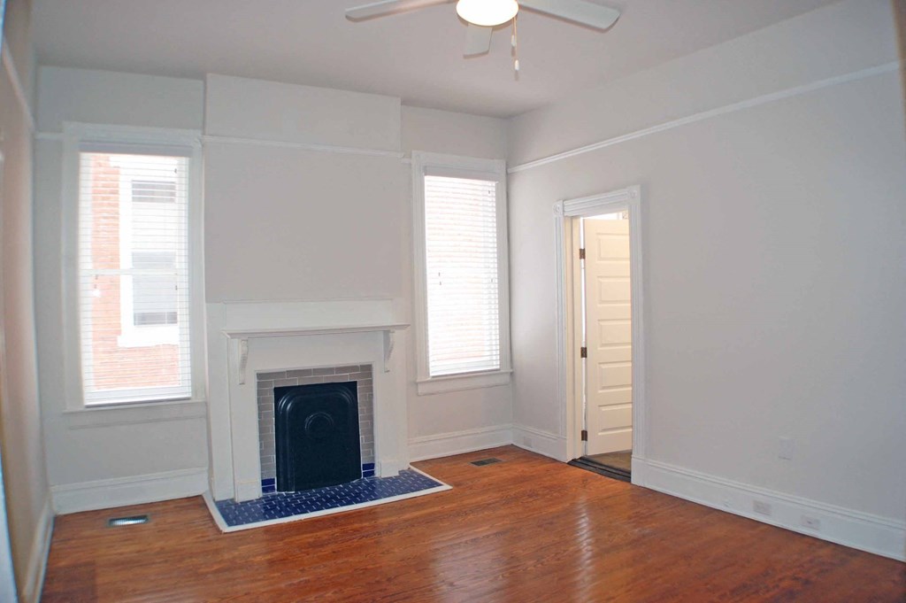 A room with a fireplace and a ceiling fan.