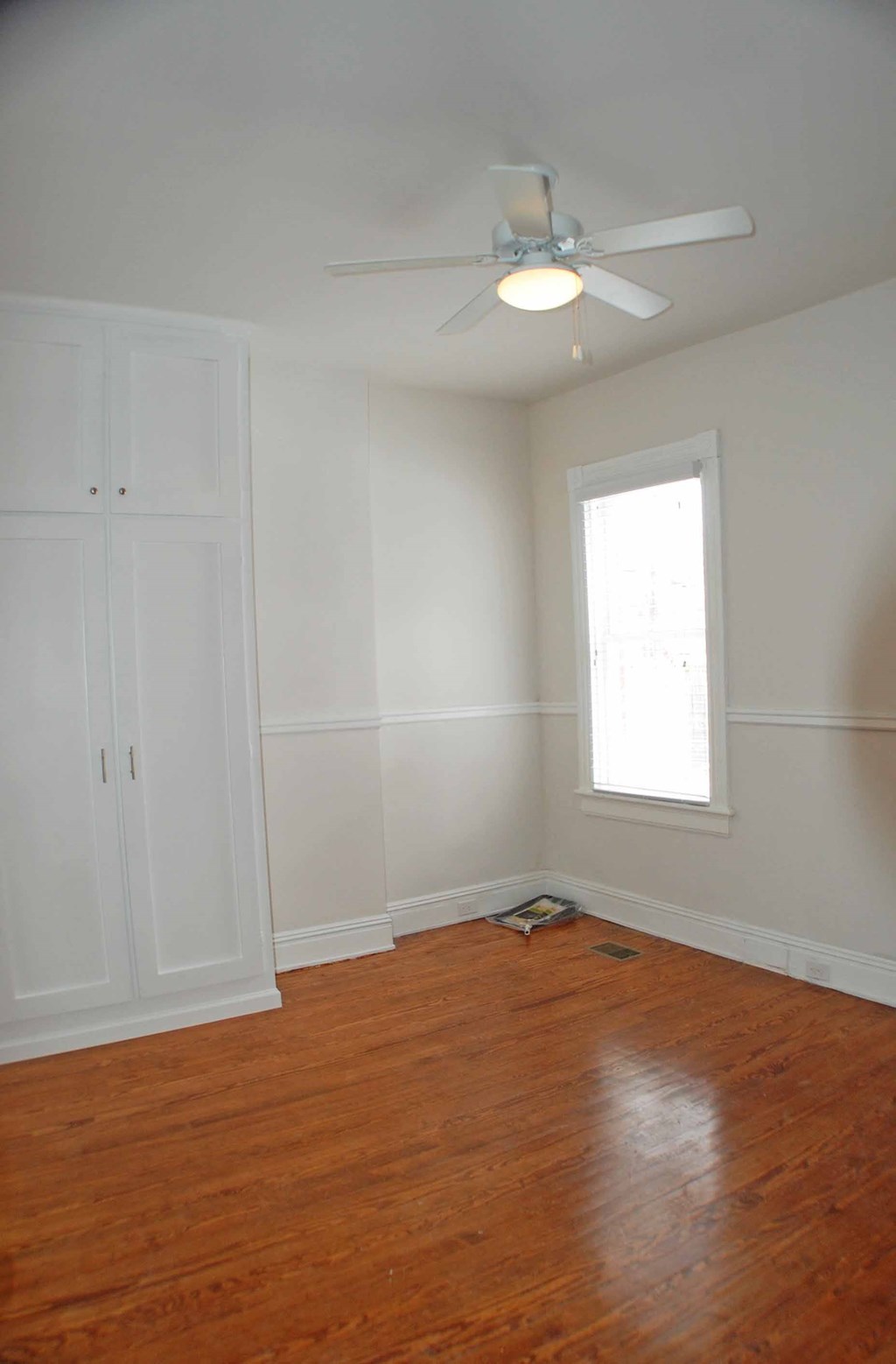 A room with a ceiling fan and a window.