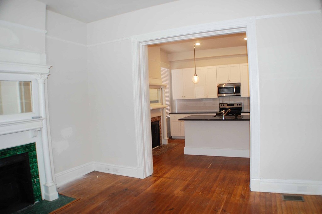 A kitchen is visible through an open doorway.