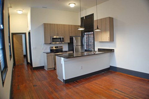 A kitchen with wooden floors and white walls.