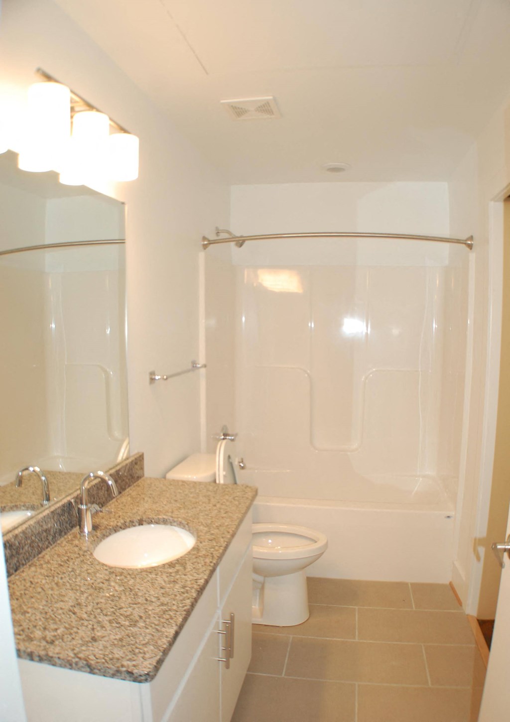 A white bathroom with a sink, toilet and shower.