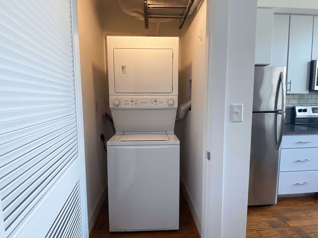 A white washing machine sits in a small laundry room.