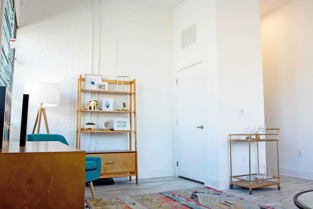 A room with a blue chair and a wooden table.