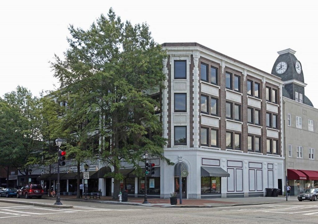 A large white building with a clock tower in the background.
